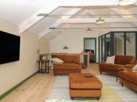A living room with a television and sofas at Reddaway Threshing Barn near Okehampton
