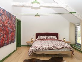 A bedroom with a bed and bedside tables at Reddaway Threshing Barn near Okehampton