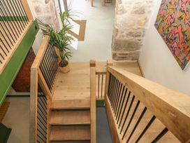 A staircase with wooden flooring and potted plant at Reddaway Threshing Barn near Okehampton