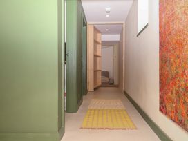 A hallway with a shelf and rug at Reddaway Threshing Barn near Okehampton