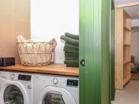 A laundry room with washing machines and stacked towels at Reddaway Threshing Barn near Okehampton