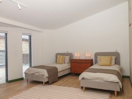 A bedroom with two beds and a bedside table at Reddaway Threshing Barn near Okehampton