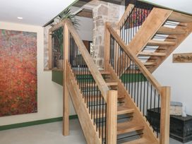 A staircase with wooden steps and railing in Reddaway Threshing Barn near Okehampton