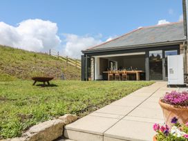 An outdoor area with a table and chairs at Reddaway Threshing Barn near Okehampton