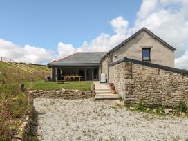 An outdoor area with a house patio and dining set at Reddaway Threshing Barn near Okehampton
