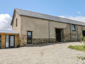 A large building with windows and door surrounded by gravel at Reddaway Threshing Barn near Okehampton