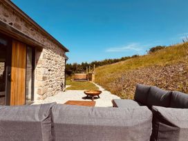 An outdoor area with a sofa and coffee table at Reddaway Threshing Barn near Okehampton