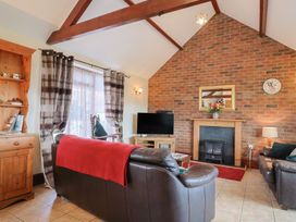A living room with a sofa and television at Daisy Cottage in Whitchurch Canonicorum near Charmouth