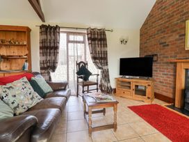 A living room with a sofa and television at Daisy Cottage in Whitchurch Canonicorum near Charmouth