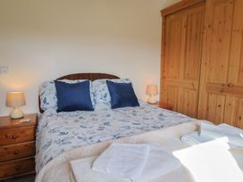 A bedroom with a bed and bedside lamp at Daisy Cottage in Whitchurch Canonicorum near Charmouth