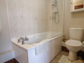 A bathroom with a bathtub and shower enclosure at Daisy Cottage Whitchurch Canonicorum near Charmouth