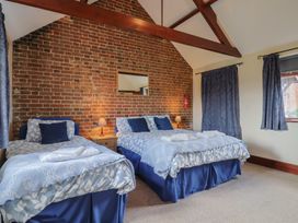 A bedroom with two beds and a mirror at Daisy Cottage Whitchurch Canonicorum near Charmouth
