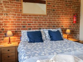 A bedroom with a bed and lamps on nightstands at Daisy Cottage near Whitchurch Canonicorum