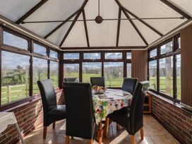 A conservatory with a table and chairs at Daisy Cottage in Whitchurch Canonicorum near Charmouth
