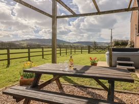 An outdoor area with a picnic table and hot tub at Daisy Cottage Whitchurch Canonicorum near Charmouth