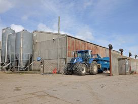 A tractor and storage silos at a farm at Daisy Cottage in Whitchurch Canonicorum near Charmouth
