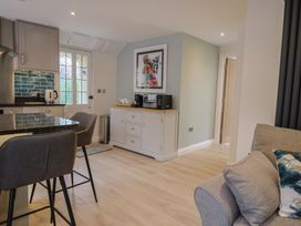 A kitchen with bar stools and a cabinet at Flat 2 The Cedars in Lyme Regis