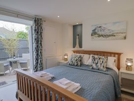 A bedroom with a bed and table at Flat 2 The Cedars in Lyme Regis