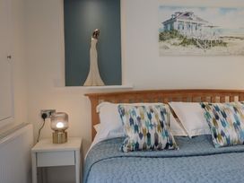 A bedroom with a bed and wall art at Flat 2 The Cedars Lyme Regis