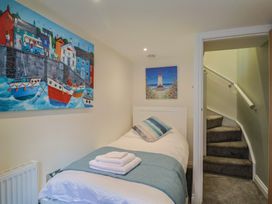 A bedroom with a single bed and paintings on the wall at Flat 2 The Cedars in Lyme Regis