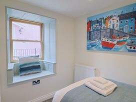 A bedroom with a window and a painting at Flat 2 The Cedars Lyme Regis