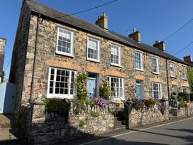 A row of stone houses with flower beds at Ty Clyd in Newport, Pembrokeshire