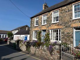 A stone house with flowers and a garden wall at Ty Clyd in Newport, Pembrokeshire