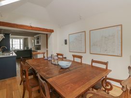 A dining room with a wooden table and maps on the wall at Ty Clyd Newport, Pembrokeshire