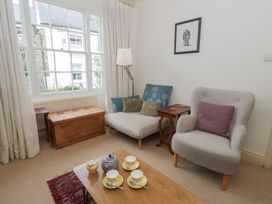A living room with a sofa, armchair, coffee table, and a window at Ty Clyd in Newport, Pembrokeshire