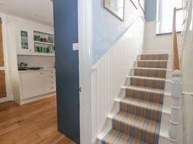 A hallway with stairs and kitchen cabinet at Ty Clyd, Newport, Pembrokeshire