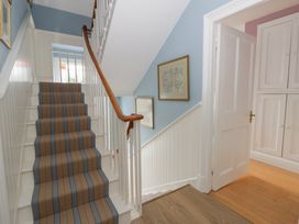 A staircase with handrail and door at Ty Clyd in Newport, Pembrokeshire