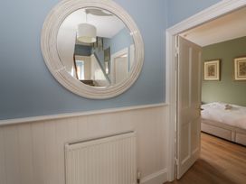 A hallway with a mirror and door at Ty Clyd in Newport, Pembrokeshire