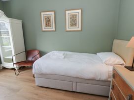 A bedroom with a bed and armchair at Ty Clyd in Newport, Pembrokeshire