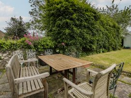 A garden with wooden and metal chairs around a table at Ty Clyd Newport, Pembrokeshire