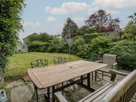 A garden with wooden table and chairs at Ty Clyd Newport, Pembrokeshire