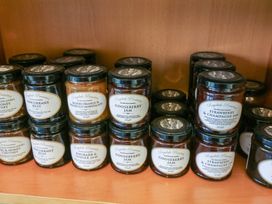 Jars of Raydale Preserves including jelly marmalade and jam on wooden shelves at Charlottes in Holbeach