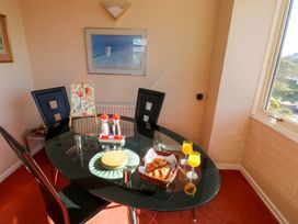 A dining room with a glass table two glasses of orange juice and a basket with croissants at Rosa in Torquay