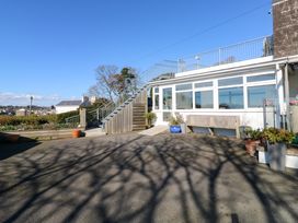 An outdoor area with a staircase leading to a roof terrace and potted plants near a white building at Rosa in Torquay