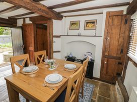 A dining area with a wooden table set for four and exposed wooden beams at Church View in Welford-On-Avon