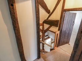 A staircase with wooden beams and a wooden door at the top at Church View in Welford-On-Avon