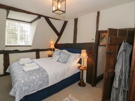 A bedroom with a bed and bedside tables with lamps near a window at Church View in Welford-On-Avon