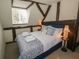 A bedroom with a bed folded towels on bedding and two bedside lamps at Church View in Welford-On-Avon