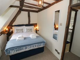 A bedroom with a double bed and wall mirror at Church View in Welford-On-Avon