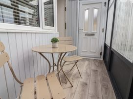 A conservatory with a table and chairs at Driftwood in Rhyl