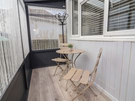 A conservatory with a table and chairs at Driftwood in Rhyl