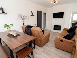 A living room with a sofa and dining table at Driftwood in Rhyl