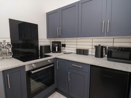 A kitchen with modern appliances and cabinetry at Driftwood in Rhyl