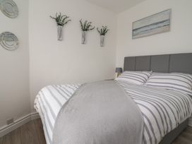 A bedroom with a bed and wall art at Driftwood in Rhyl