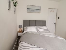 A bedroom with a bed and nightstand at Driftwood in Rhyl