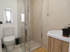 A bathroom with a shower and toilet at Driftwood in Rhyl